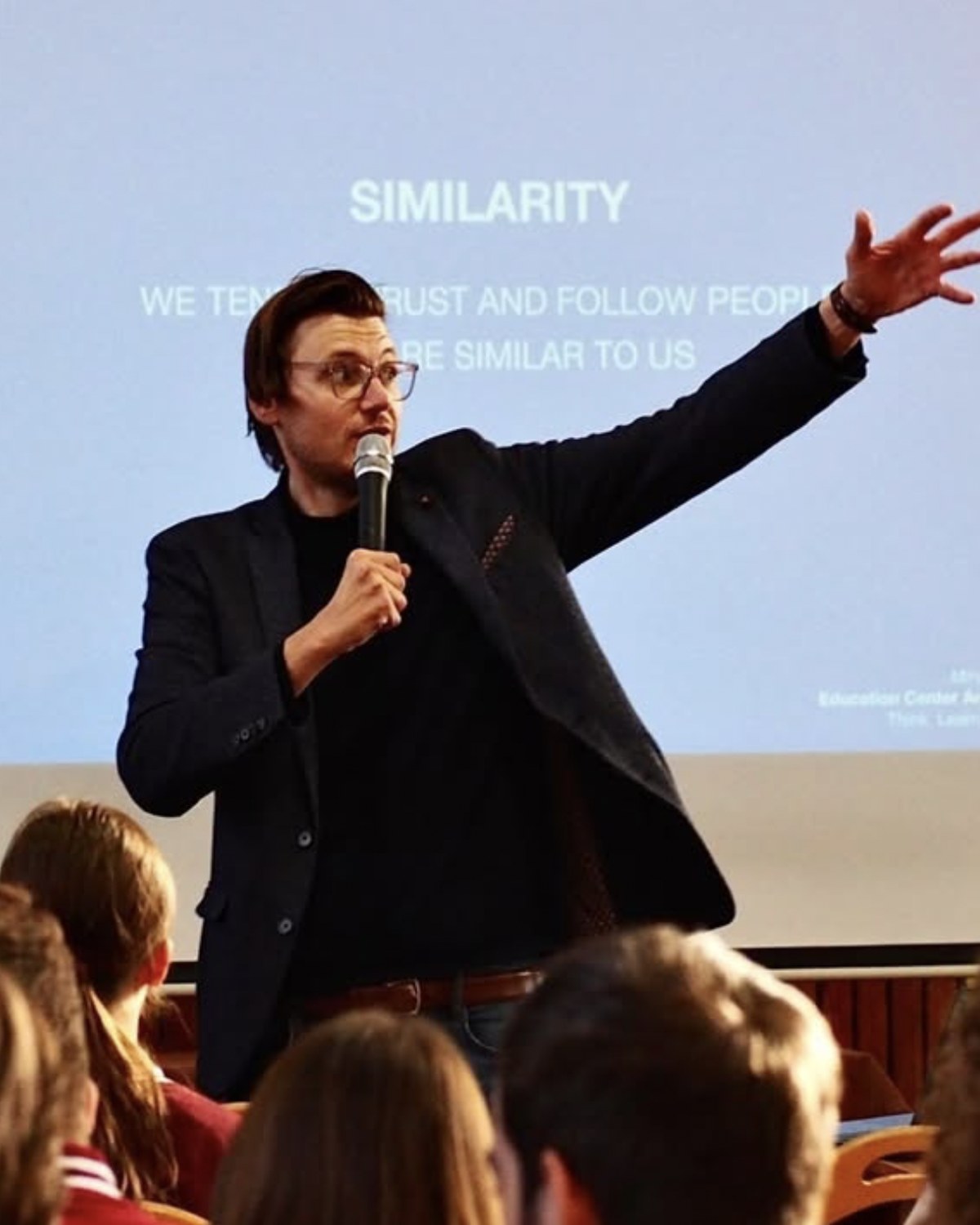 Mr. Miha Andrič addressing a full lecture hall with a microphone