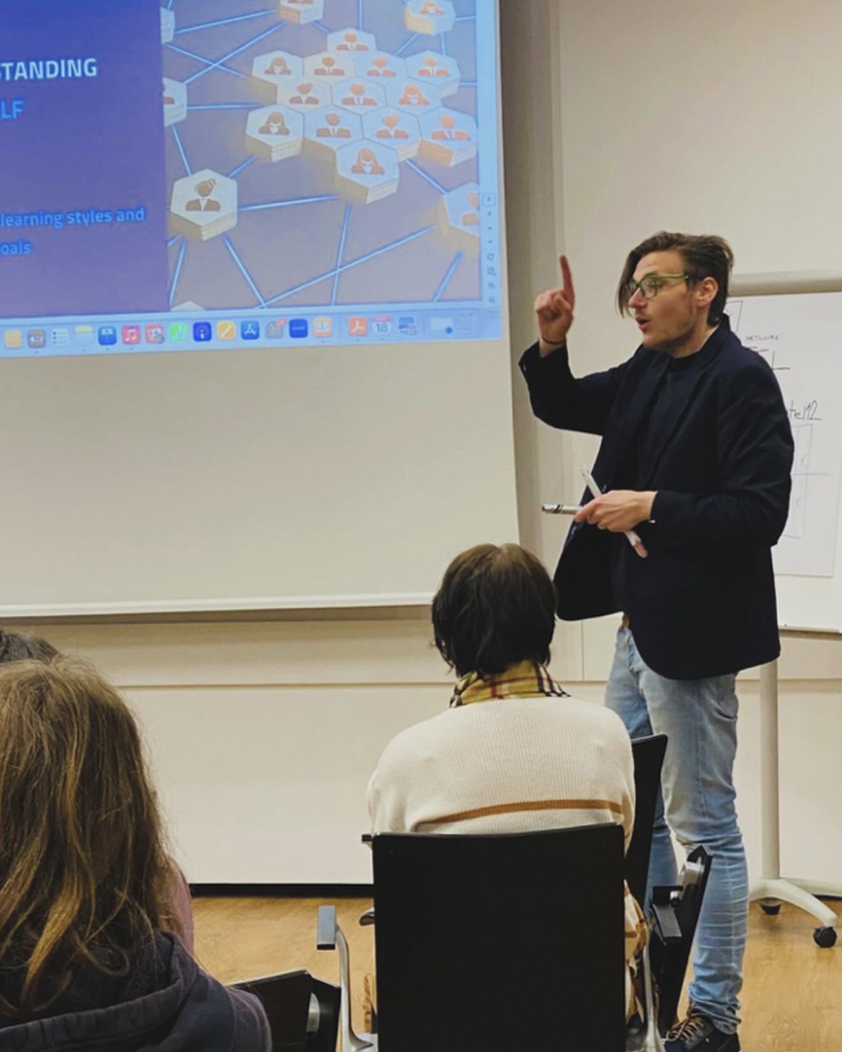 Mr. Miha Andrič lecturing beside a projected presentation